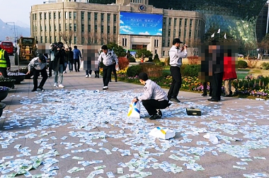 KOREANS IGNORE SCATTERED CASH IN DOWNTOWN SQUARE